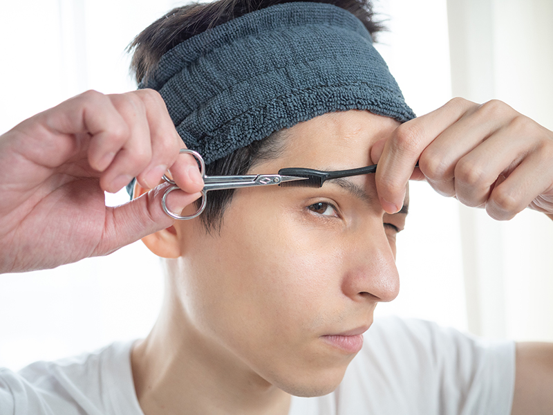 眉毛を整えている男性の写真